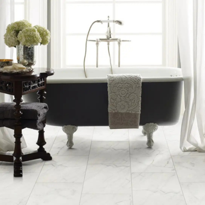 Elegant bathroom featuring light marble-look tile flooring, a dark clawfoot tub, and classic design details.